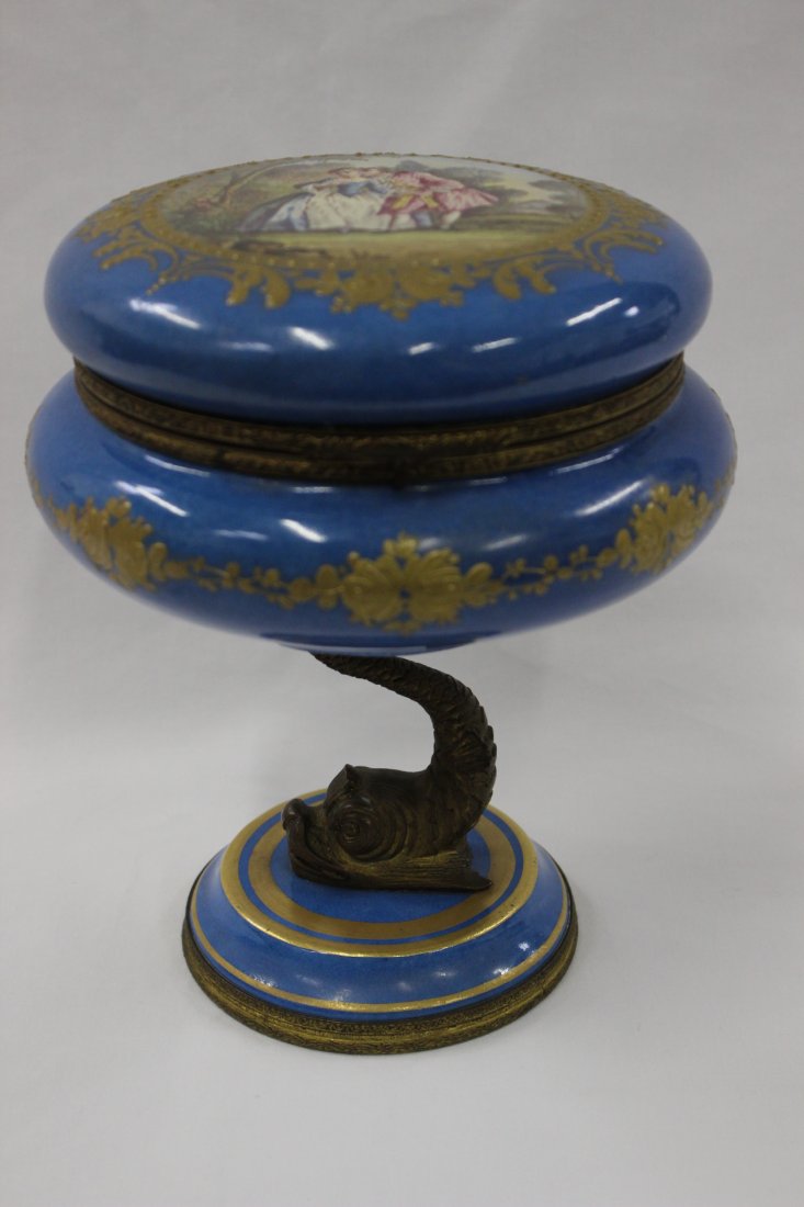 Unusual Sevre's porcelain box: Unusual Sevre's porcelain box, top painted with lover scene and with a gilt dolphin motif base, 8"Hx6.75"dia
