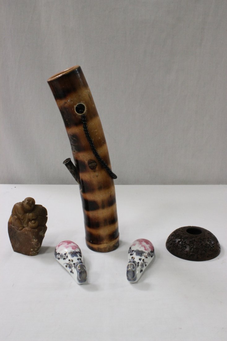 5 items: 5 items, a wood carved water dripper (1.15"Hx3.5"dia), monk motif Shoshan stone boulder (3.6"x2.35"x1.95"), 2 famille rose porcelain belt buckles (4.05"x1.55"x1.05" each), and a bamboo pipe (11"Lx2.4"