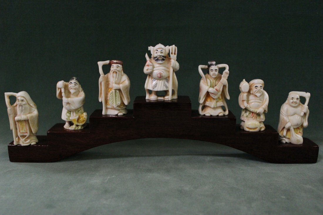7 Japanese ivory carved netsuke on stand: 7 Japanese ivory carved netsuke (2.1"H each) on stand (2.45"Hx12"x1.15")