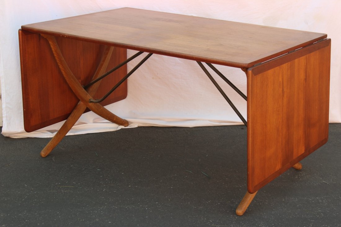 Danish teak wood dining table by Hans J. Wegner: An important Danish modern teak wood drop-leaf dining table (28.2"Hx33.75"x95") by Hans J. Wegner. Table features two 21.5" drop leaves, table measures 52" when folded, mark to underside