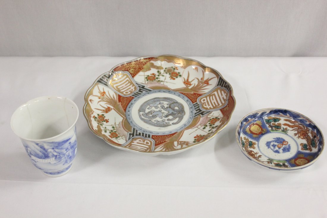 2 antique Japanese Imari plates, and a wine cup: 2 antique Japanese Imari plates (1.5"Hx8.5"dia, 1.15"Hx4.5"dia), and a blue and white wine cup (3.5"Hx3.25"dia) (cup rim chip and hairline)