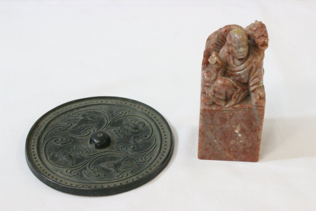 A shoshan stone seal and a small bronze mirror: A shoshan stone seal (3.85"Hx1.75"x1.65") and a small bronze mirror (4.35"dia)