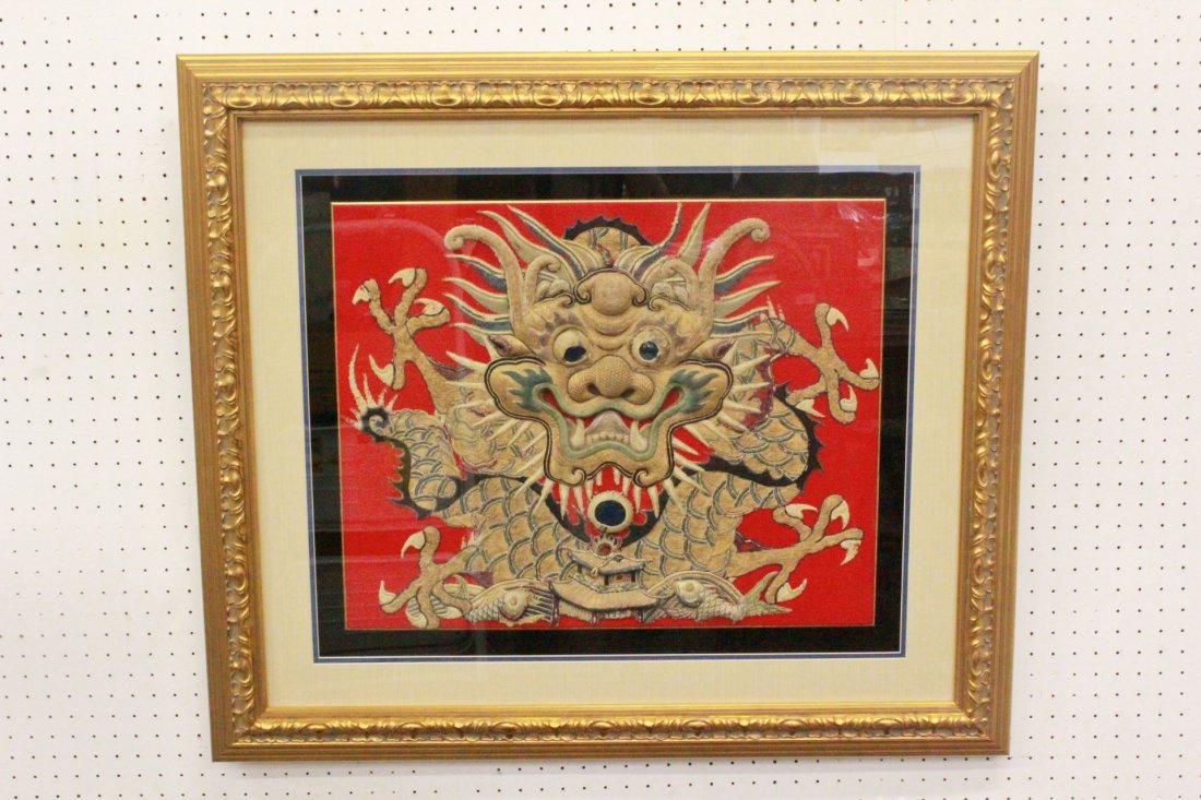 Chinese framed embroidery of dragon head: Chinese framed embroidery (19.5"x24") depicting dragon head, the eye and the beard in the mouth are replacement. This piece is cut off from a large Chinese robe (the fabric of the robe was deteriorate