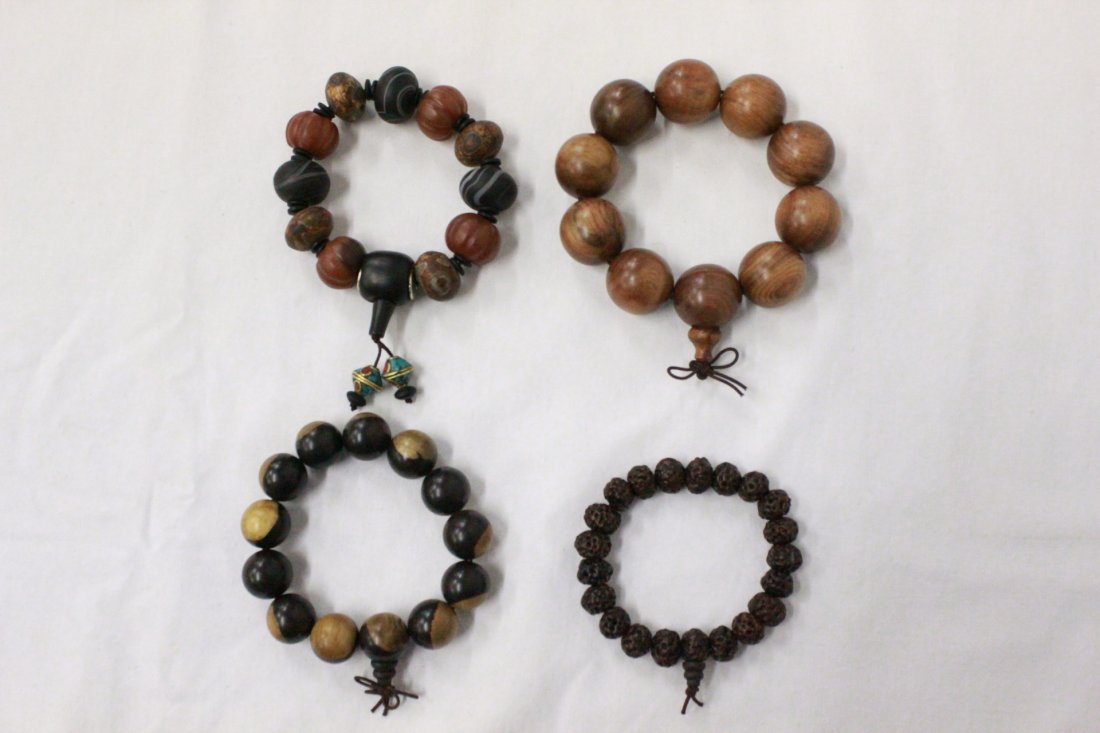 4 bracelets: 4 bracelets; one possible huanghuali (0.9"dia (10)), a dzi bead (approx. 0.8"dia (11)), and a seed like bead (0.5'dia (21)) bracelet, (0.65"dia (13))