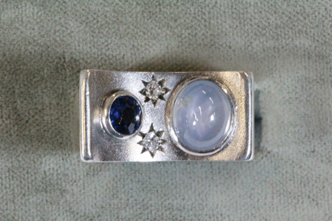 A retro design silver star sapphire ring: A retro design silver ring (size 6), center a natural star sapphire wt. approx. 6.0ct, side with 2 small diamonds and a blue stone, also enhanced by 6 rose cut diamonds and 4 blue stones on side