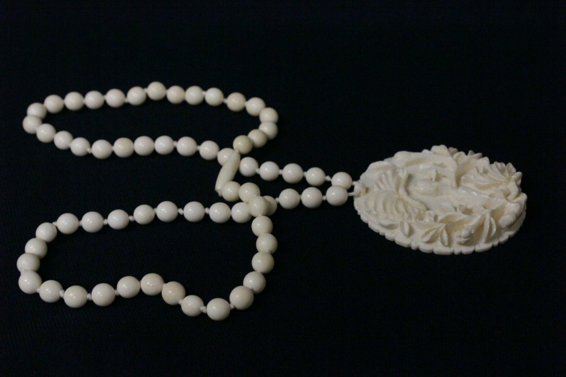 Ivory pendant attached to an ivory bead necklace (1 of 9)