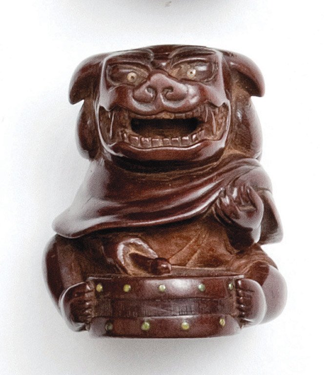 A Japanese wood netsuke of a figure in a shishi ma: A Japanese wood netsuke of a figure in a shishi mask with drum, Meiji period (1868-1912) signed 4.25cm high