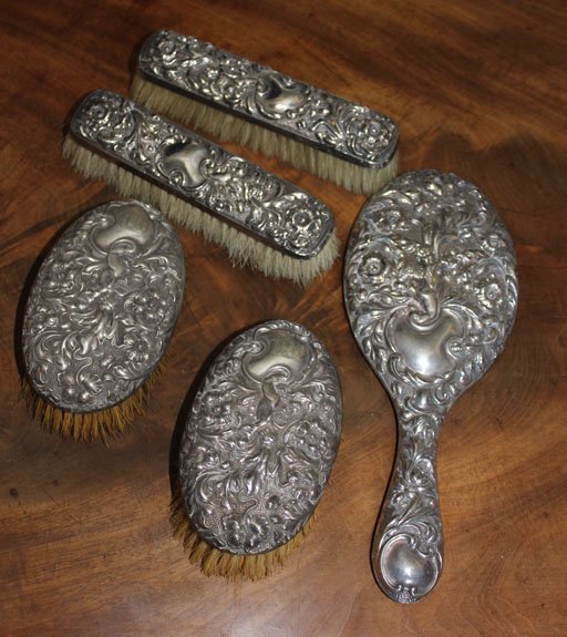 A sterling silver Victorian toilet set, Birmingham: A sterling silver Victorian toilet set, Birmingham hallmarks comprising a mirror, two gentleman’s hair brushes and two clothes brushes