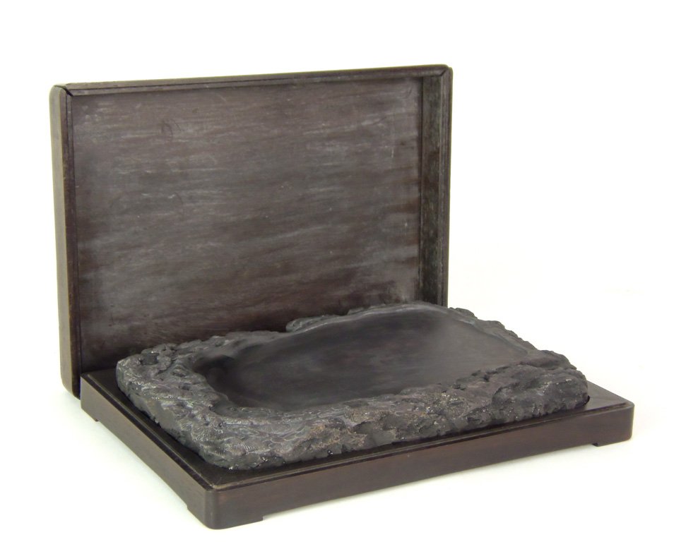 A Chinese Duan rectangular ink-stone, early 20th c: A Chinese Duan rectangular ink-stone, early 20th century decorated on the upper surface and sides with a gnarled pine amid rockwork, fitted hardwood case 16 x 24cm