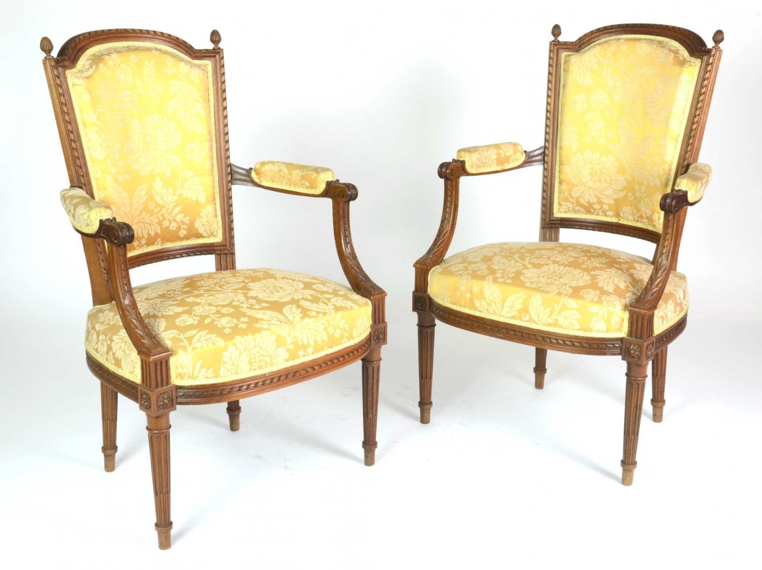 A pair of Louis XVI style carved walnut fauteuils, Fren