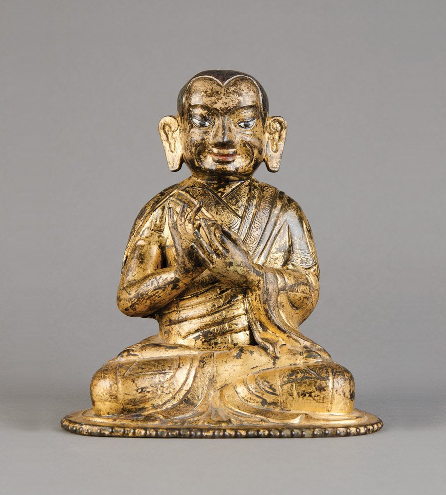 A seated Tibetan gilt-copper repousse image of a monk, : A seated Tibetan gilt-copper repousse image of a monk, circa 18th century His robes finely chased, the eyes inlaid, possibly an image of Tsongkapa, unsealed 23.5cm high, 20.6cm wide Provenance Sotheby