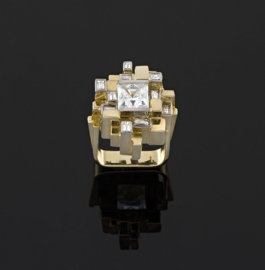 A diamond and clear stone ring by Andrew Grima, circa: A diamond and clear stone ring by Andrew Grima, circa 1970 of stepped abstract design, set with a central princess cut clear stone and ten baguette diamonds. Estimated total weight 0.50 carats. 18ct y