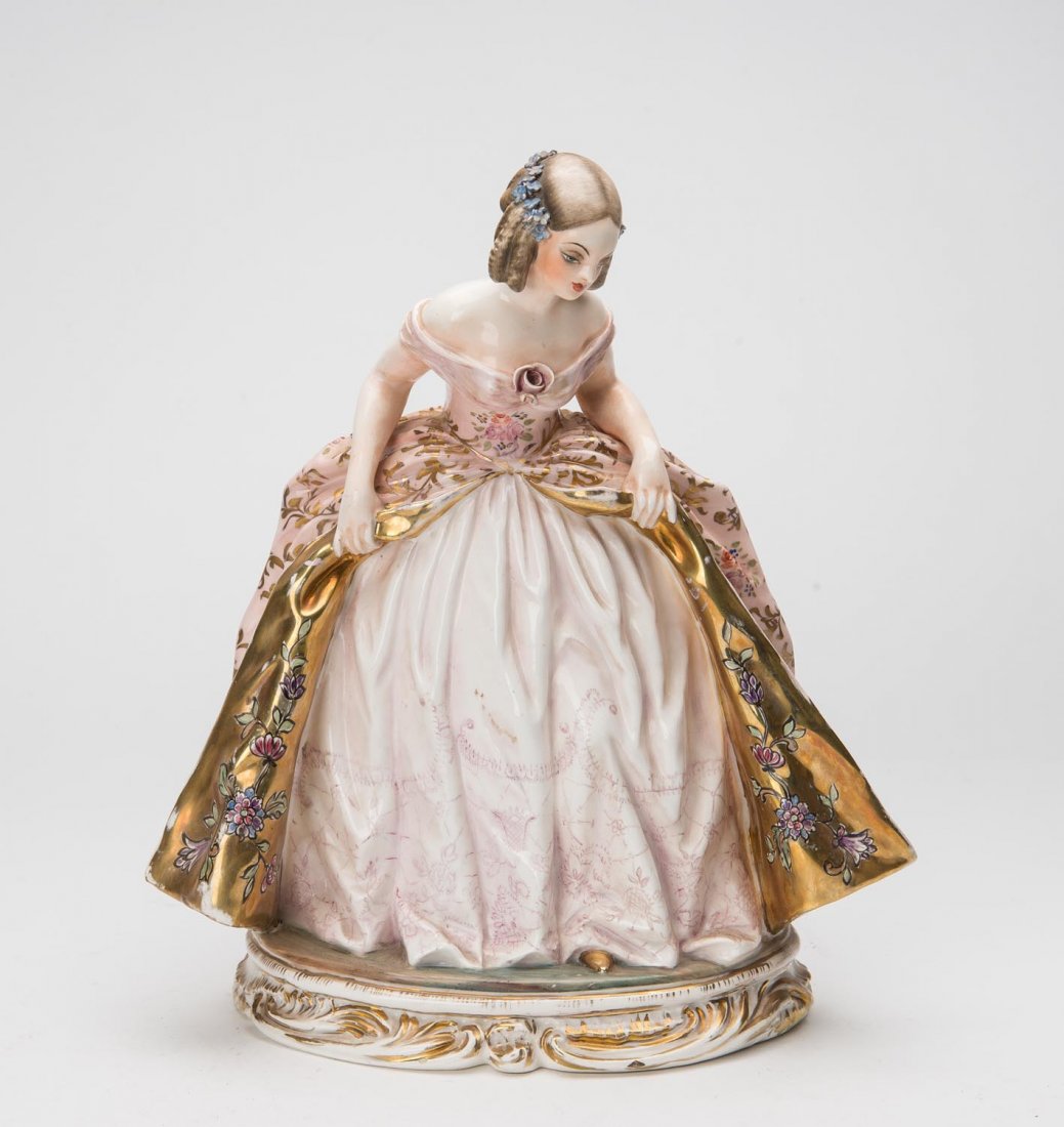 An Italian Guido Cacciapuoti porcelain figure of a: An Italian Guido Cacciapuoti porcelain figure of a young beauty in a ball gown, No 1082, 28cm high
