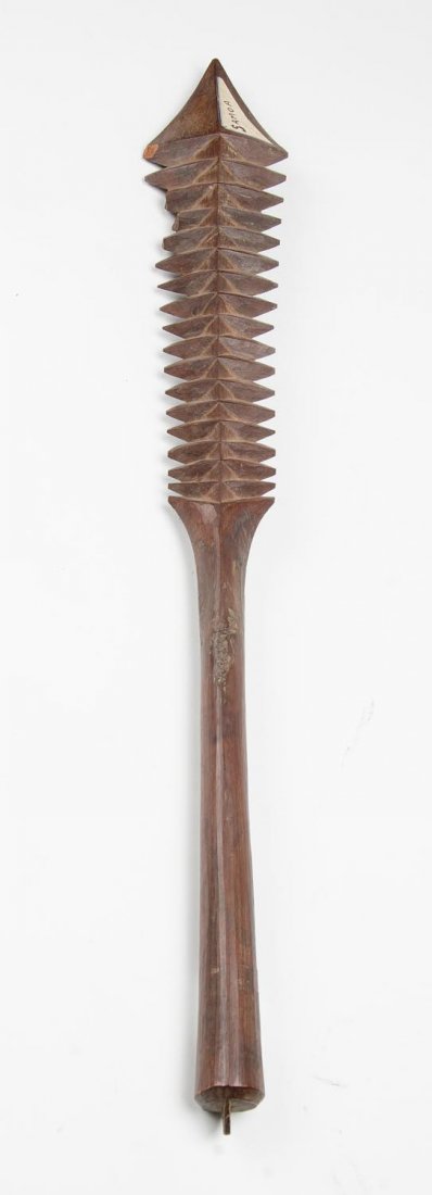 A Gugu war club Tonga. Flat form shaped club with: A Gugu war club Tonga. Flat form shaped club with intricate incised decoration on one side, 85 cm.