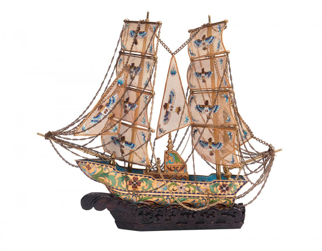 A Chinese silver gilt filigree and multi-coloured: A Chinese silver gilt filigree and multi-coloured enamel model of a sailing ship on a carved wooden base. 40cm high