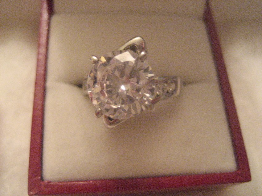 Very Large Sterling Zirconia Ring: Size 7.25. Has a beautiful 3 carat solitaire cubic zirconia with an additional carat in smaller stones. This is a diamond lookalike and we won't tell if you won't tell.