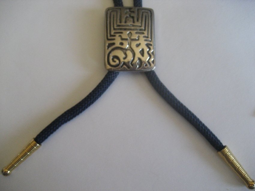 Hopi Coin Silver Bolo w/ 10K Gold Plated String: This is the famous maze pattern. It is 1 and 1/8” and 1.5” long.