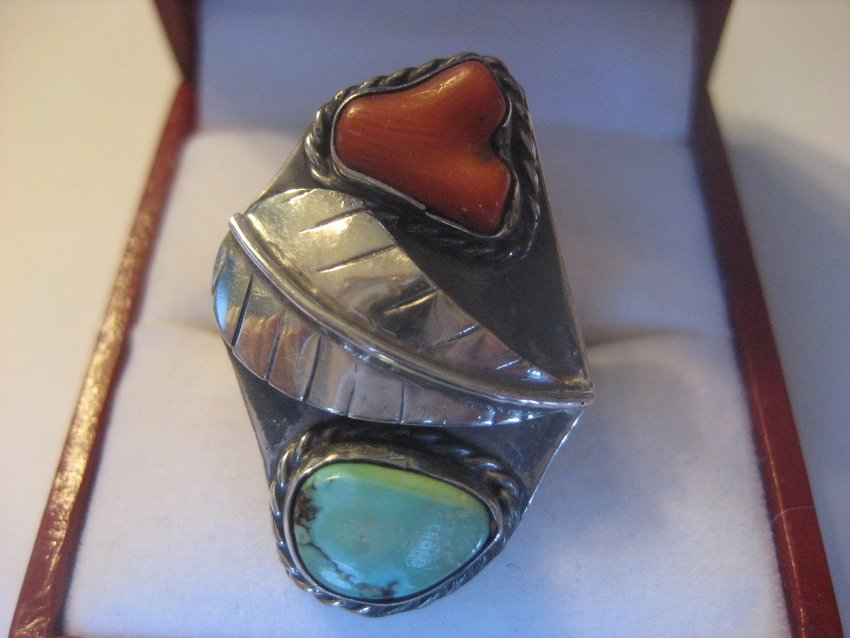 Navajo Sterling Turquoise & Coral Feather Ring: Weighs 4.7 grams, size 7.5, and is .75” wide and 1” long. Beautiful stones in a beautiful ring – the circular feathers are a tribute to the Creator.