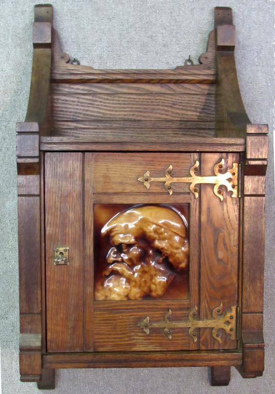 AESTHETIC MOVEMENT OAK WALL CUPBOARD, INSET TILE: GLAZED BROWN TILE IS SIGNED ON REVERSE BY J. & J.G. LOW, CHELSEA, MA; 28 1/2" X 15"