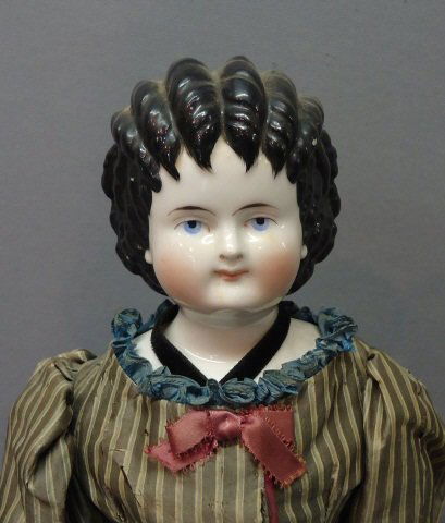 GERMAN CHINA HEAD DOLL 'CURLY TOP': WITH CLOTH BODY, BISQUE ARMS & LEGS, PAINTED BOOTS; BOTH FEET HAVE REPAIRS; 20.5"