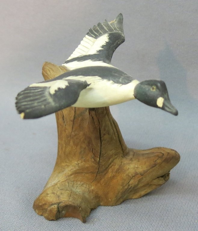 RUSS BURR CARVING OF A FLYING DUCK: WITH 5 1/2" WINGSPAN; DAMAGE TO WING
