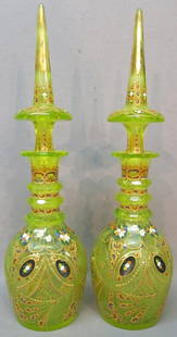 PAIR OF IMPRESSIVE BOHEMIAN GLASS DECANTERS: CUT LIME GREEN GLASS WITH ENAMEL AND GILT DECORATION, THREE APPLIED AND CUT-FACETED RINGS; 21" TALL; SMALL FLAKES TO ONE BOTTLE MOUTH (AS SHOWN IN PHOTO), ONE SMALL CHIP IN ONE OF THE BLACK PAINTED ME