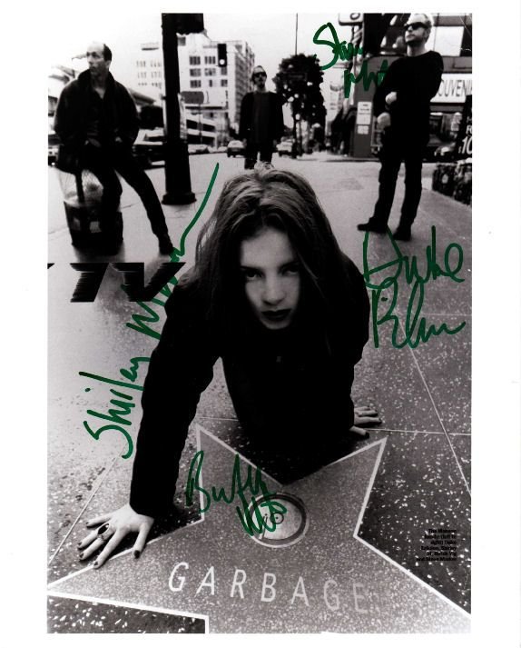 Garbage Signed Promo Photo Inc Shirley Manson: This item is an original 13" x 10" promotional photo signed by Shirley Manson, Butch Vig and Duke Erikson and Steve Marker of Garbage. The item, which was signed in Milan, Italy, on 7/7/99, is a perfe