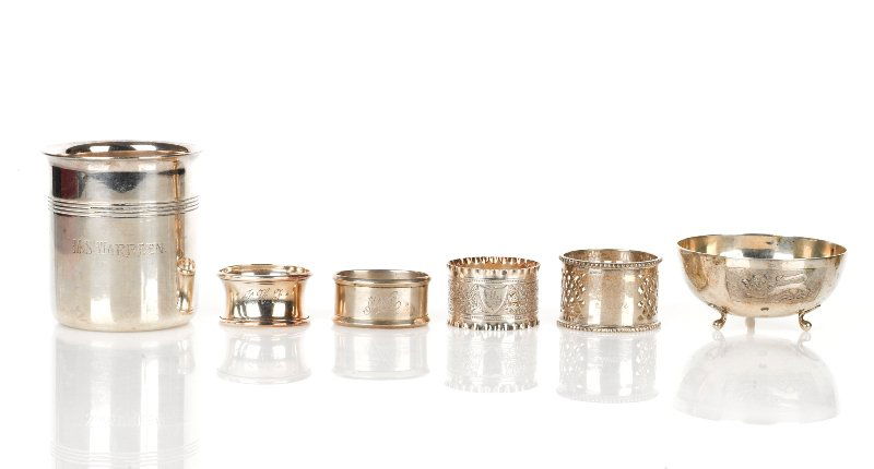 Collection of Silver Table Accessories: comprising four assorted napkin rings, two silver and two plated, a silver bowl of hemispherical form on three feet with lion motif, marked 800, together with a plated beaker with a reeded girdle (6)