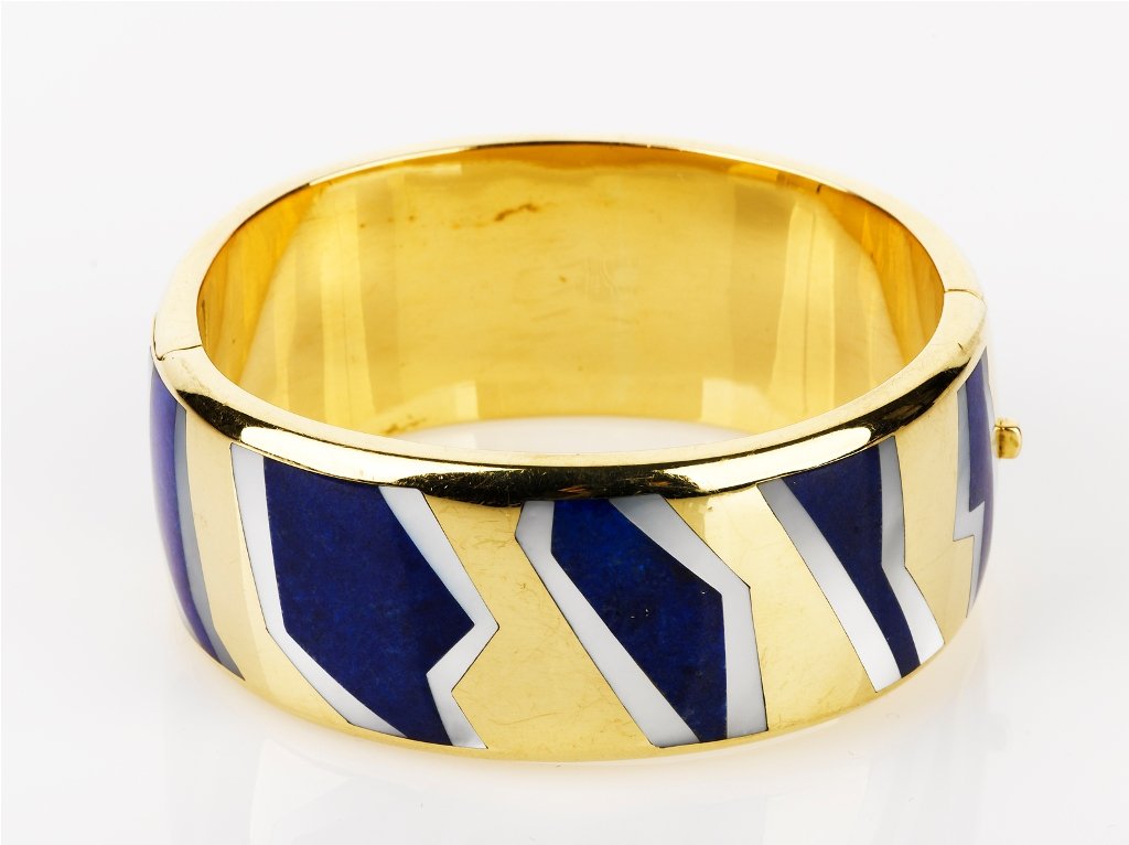 Tiffany and Co., Bangle: 18ct yellow gold hinged bangle, set with lapis lazuli and mother of pearl, snap lock clasp and concealed safety clip, stamped 'T&CO. 18ct 750' weight 76 grams