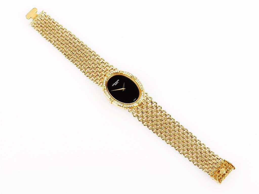 Patek Philippe,: 18ct yellow gold case, bracelet and clasp, single diamond set bezel, manual wind movement, black dial total weight 69 grams
