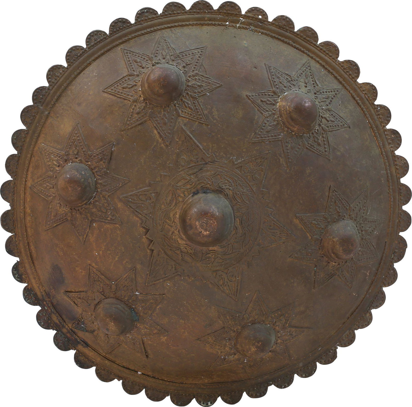 BATAK BRASS SHIELD: 19th century. 11 1/2" diameter, with scalloped edge and domed body with 7 bosses, each with an eight-point starbase. Decorated throughout with stylized foliage in various arrangements. A few minor cas