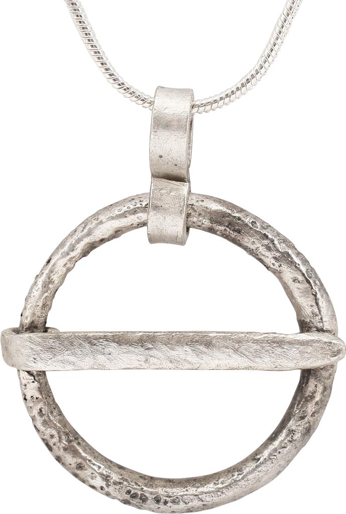 VIKING PROTECTIVE BROOCH NECKLACE C.870-1066: Cambridgeshire, England. Circular bronze, over 1" diameter of rounded section and tapered cross pin. Surface textured from burial. Worn in numbers on the surface of the jerkin, these small metal brooc