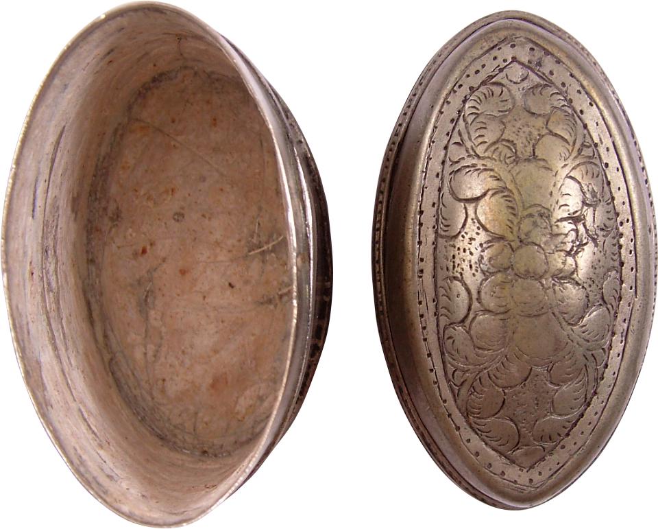ASIAN LIME CONTAINER: 18th-19th century. White metal, of oval form, about 2 1/4" length. The domed top chiseled in foliate designs. The inside with remnants of lime. Chewing the betel nut is a widespread centuries-old cust
