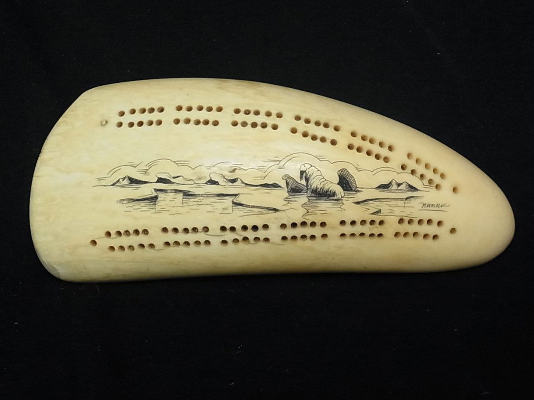 Vintage Artist Signed Walrus Ivory Scrimshaw Whale: Vintage Artist Signed Walrus Ivory Scrimshaw Whale Tooth Cribbage Board by Nanuk w/ Landscape Decoration Eskimo Inuit or Other Native Alaska or Arctic Culture Description: Fitted with felt bottom.