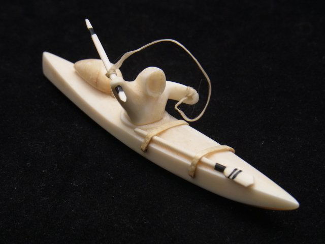 Signed M. Milligrock Diomede AK Alaskan Eskimo Kay: Signed M. Milligrock Diomede AK Alaskan Eskimo Kayak Miniature Sculpture Carving with Stylized Seal & Spear 4 ½” Long Description: Tiny spear attached by string is removable from hunter’s hand.