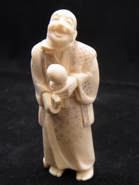 Signed Japanese Okimono Ivory Carving Man Holding: Signed Japanese Okimono Ivory Carving Man Holding Fan & Objects 3 ¼” High Description: Signed on base of feet. Approx. Dimensions or Size: 3 ¼” high Hess Fine Auctions Shipping: Continenta
