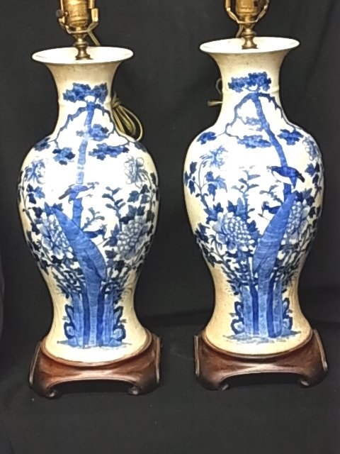 Pair Large Blue & White Canton Related Ware Vase Fo: Description: Pair Large Blue & White Canton Related Ware Vase Form Table Lamps Bird & Blossom Motif. Lamp finials do not match. One is a carved Jade medallion and the other is carved wood with red hue