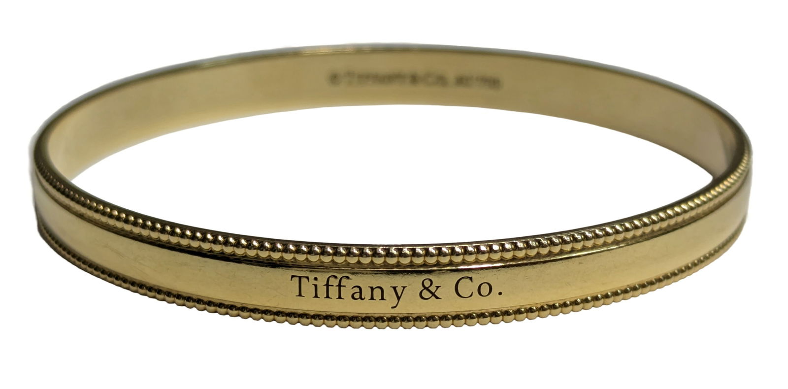 Heavy 18K Gold Tiffany & Co Milgrain Bangle Designer Signed 7.75 Inch Bracelet: Described & Photographed By: Dillon CNX 0445 1430 Title: Heavy 18K Gold Tiffany & Co Milgrain Bangle Designer Signed 7.75 Inch Bracelet Description:Heavy 18K Gold Tiffany & Co Milgrain Bangle Designer