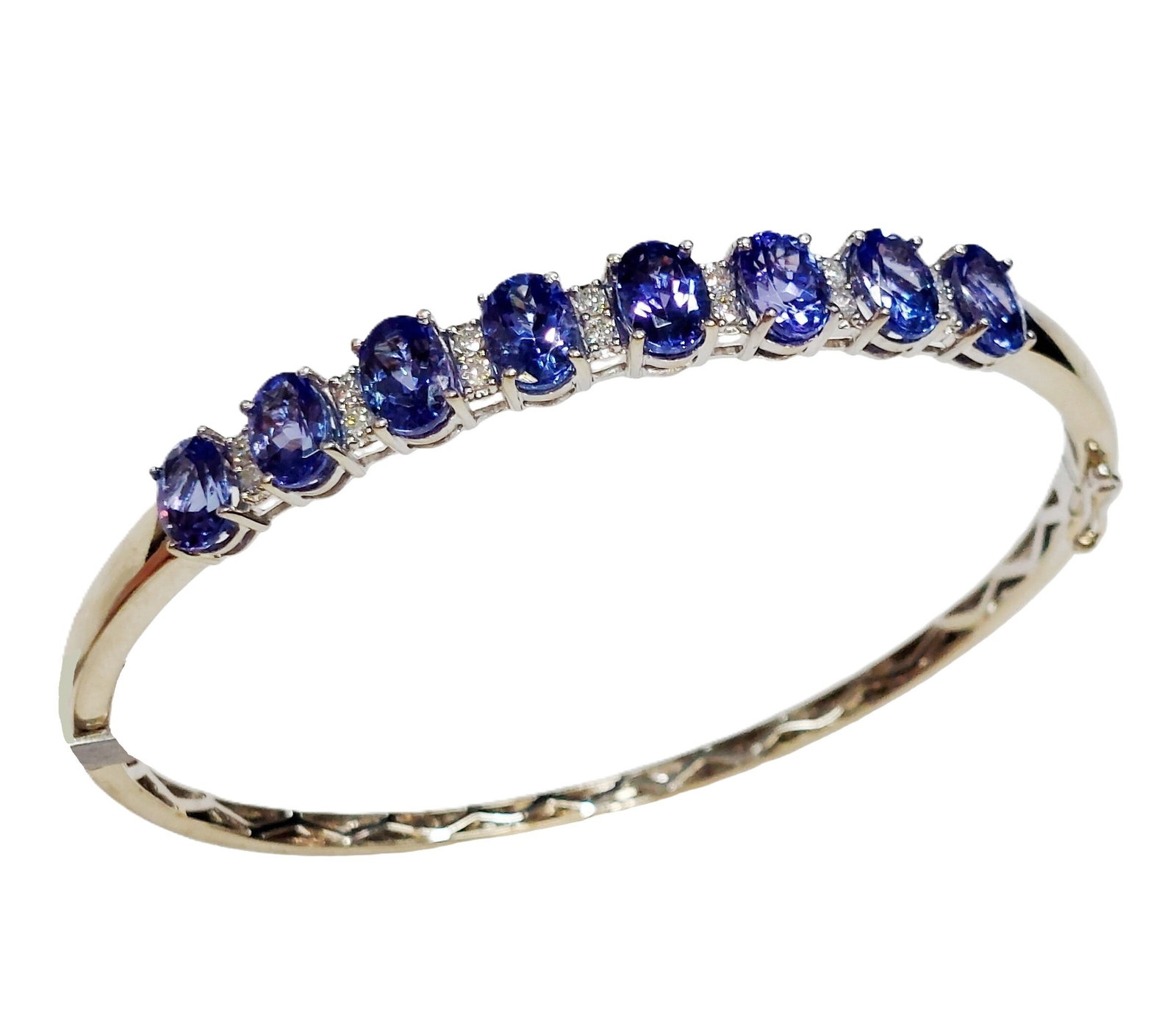 7.92ctw Gem Quality Tanzanite 14k White Gold 0.23ctw Diamond Designer Signed Bangle Bracelet: Described By: Chris Falconer NFODD Title: 7.92ctw Gem Quality Tanzanite 14k White Gold 0.23ctw Diamond Designer Signed Bangle Bracelet Description: A classic hinged bangle br