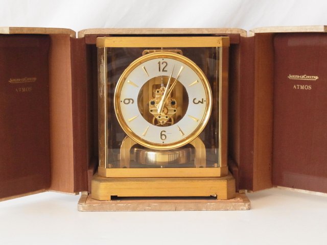 Vintage Jaeger LeCoultre Atmos Mantel Clock with Case a: Vintage Jaeger LeCoultre Atmos Mantel Clock with Case and Original Manual SIZE: Clock measures 8 1/4” wide, 9¼” tall, 6 1/4” deep, Case measures 9 3/4” wide, 10 ¼” tall, 7 ½” deep Hess 