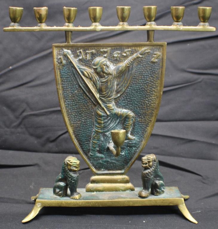 Brass Menorah: Adorned with which is possibly Moses and two Lions. Marked on bottom "Made in Israel". Measures approximately 6 3/4 inches long x 2 1/2 inches deep x 8 inches tall. From the Estate of Gene Berkowitz. 