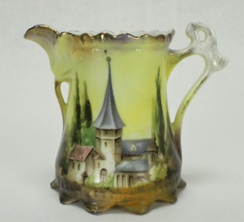 RS Prussia Porcelain Castle Scene Creamer: Measures approximately 3 1/4 inches tall x 2 inches in diameter. Wrap-around design features a scene of a castle. This image is larger than the other four. These use mold 576. Pieces have some some su