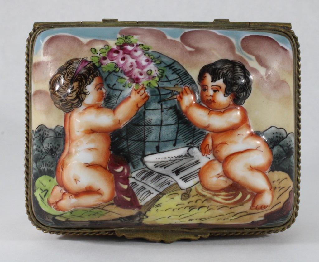 Capodimonte Porcelain Cherub Box: Measures approximately 4.5 wide x 3.5 long x 2.5 inches tall. Colored relief design of cherubs wraps around the piece. Interior has two flower designs, correlating with flowers on outside. Bottom has 