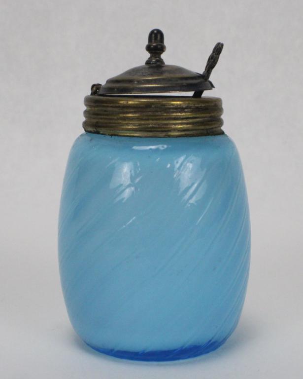 Molded Art Glass Blue Mustard Pot with Spoon: Measures approximately 3 5/8 inches tall x 2 inches long x 1 inch in diameter. Design has light blue hue with hinged Sterling Silver lid and spoon weighing approximately 9dwt.. Marked "Sterling" on ba