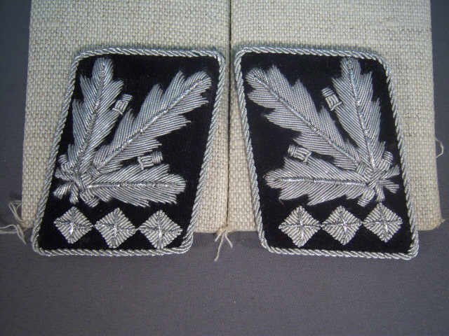Pair WWII Waffen SS Shultzstaffel Gen Collar Tabs: Pair German World War II Waffen SS Shultzstaffel General Collar Tabs. Silver bullion wire embroidered on a black wool backing. They both have twisted silver bullion wire piping.