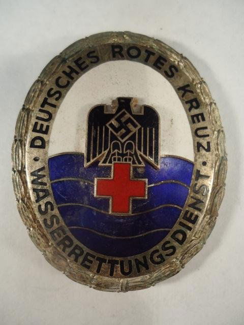 German World War II Red Cross Breast Badge: German World War II Red Cross Breast Badge. Measures 1 7/8 by 2 5/16". Has a wide vertical pin back. Maker marked 'Ges Gesch 1086'"