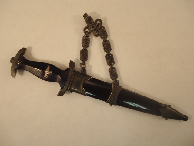 WWII Miniature Waffen SS Chained Offices Dagger w/: German World War II Miniature Waffen SS Chained Officers Dagger & Scabbard. Measures 7 1/4 long overall. The etched steel blade reads 'Meine Ehre heisst Treue' (My Honor is True). One of the chain lin