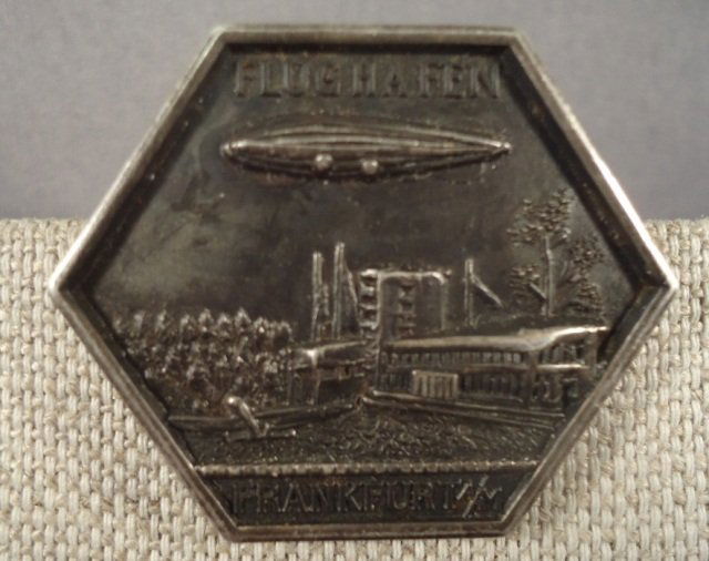 WWII Army Zeppelin Air Ship Flughafen Frankfurt Ba: German World War II Army Zeppelin Air Ship Flughafen Frankfurt Badge. Has a thin horizontal pin back. Measures 1 3/16 by 1 1/2""