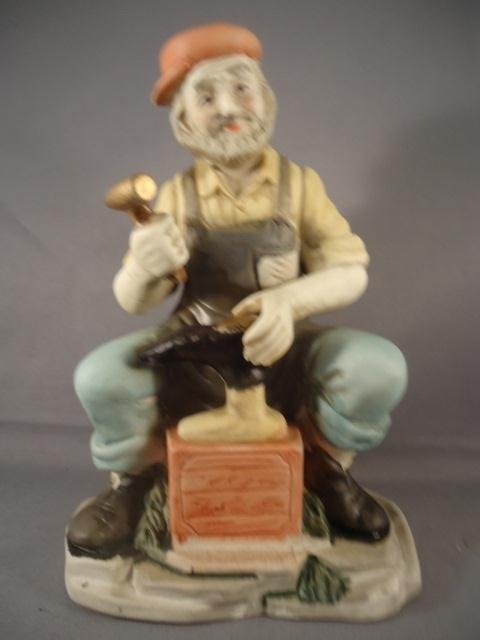 Porcelain Figure of a Man Working on a Shoe: Porcelain Figure of a Man Working on a Shoe - Unmarked - Stands 7 1/4 T"