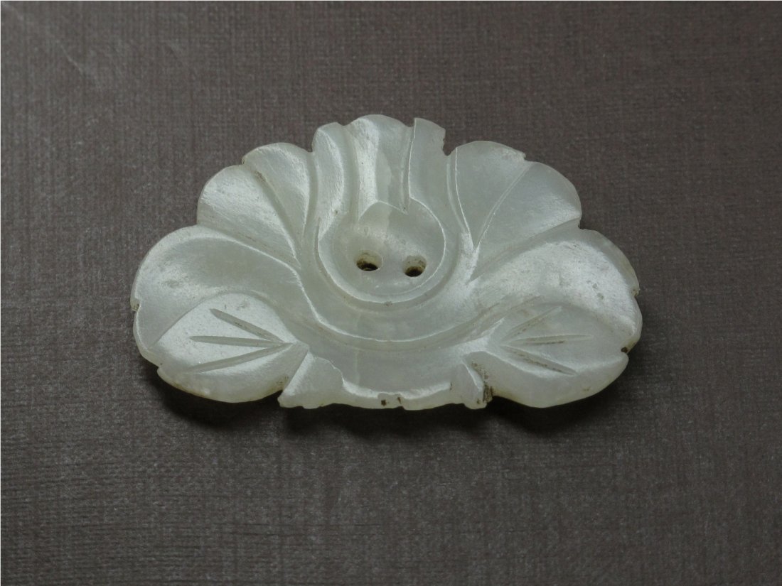 A Chinese Jade Ornament, Ming Dynasty: Elaborately Carved in relief with a floral form. L: 3.8 cm